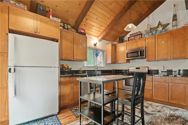 a kitchen with stainless steel appliances granite countertop a stove a sink refrigerator and a microwave