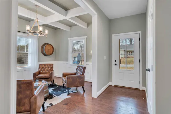 a living room with furniture a chandelier and a window