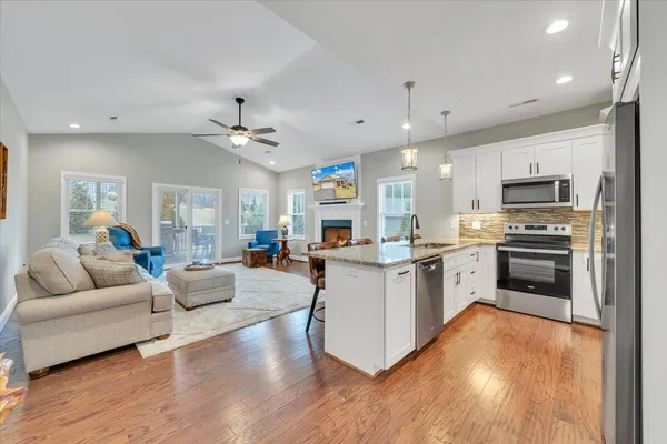a kitchen with granite countertop a stove sink and refrigerator