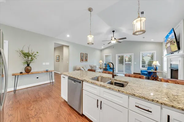 a kitchen with granite countertop living room view and living room view