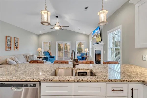 a kitchen with refrigerator a stove and chairs with wooden floor