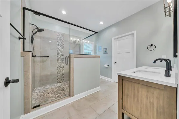 a bathroom with a shower sink and mirror