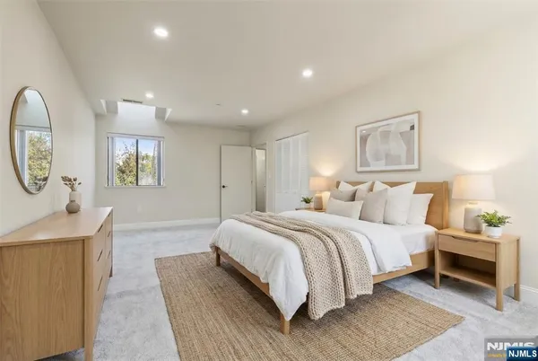 a spacious bedroom with a bed and a lamp