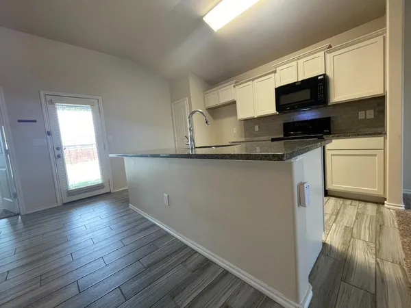 a kitchen with stainless steel appliances granite countertop a stove a sink and a microwave