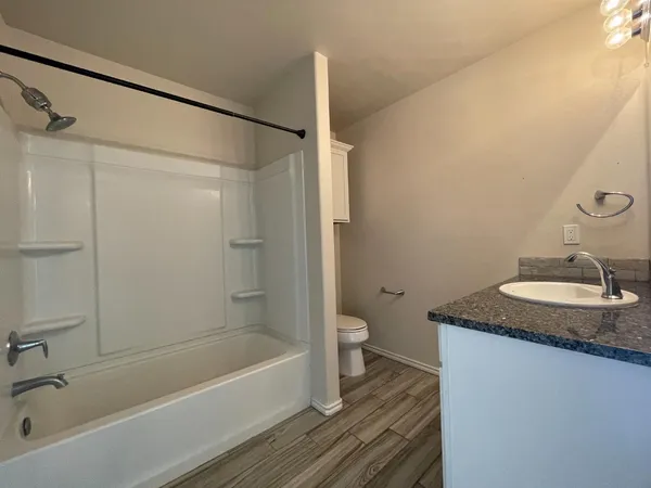 a bathroom with a granite countertop sink toilet and shower