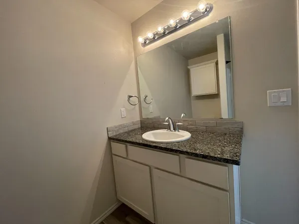 a bathroom with a granite countertop sink and a mirror