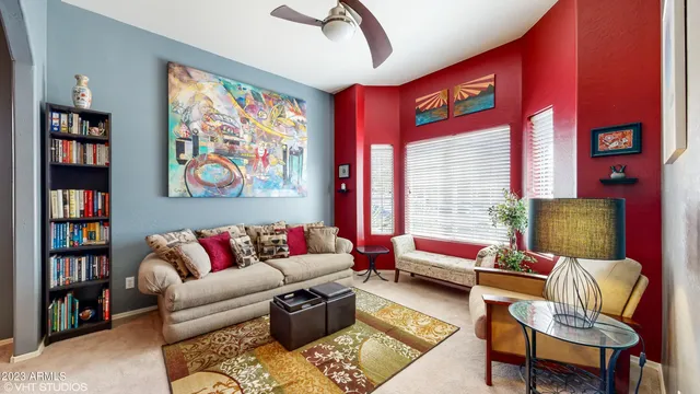 a living room with furniture a bookshelf and a window