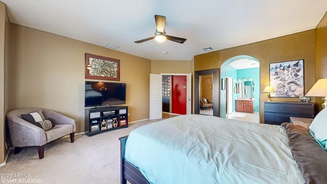 a spacious bedroom with a bed and a flat screen tv