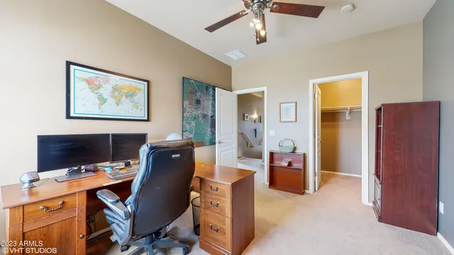 a view of a workspace with furniture and a window
