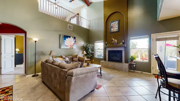 a living room with furniture a fireplace and a chandelier