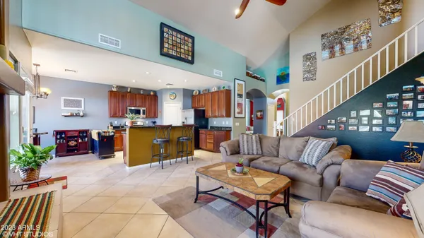 a living room with furniture kitchen view and a chandelier