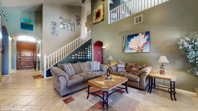 a living room with furniture a rug and a wall painting