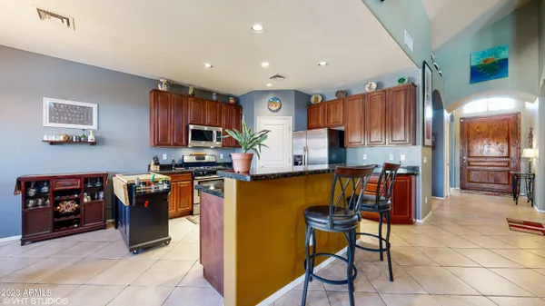 a kitchen with stainless steel appliances granite countertop a refrigerator and a stove top oven