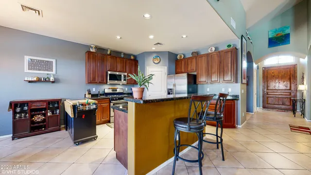 a kitchen with stainless steel appliances granite countertop a refrigerator and a stove top oven