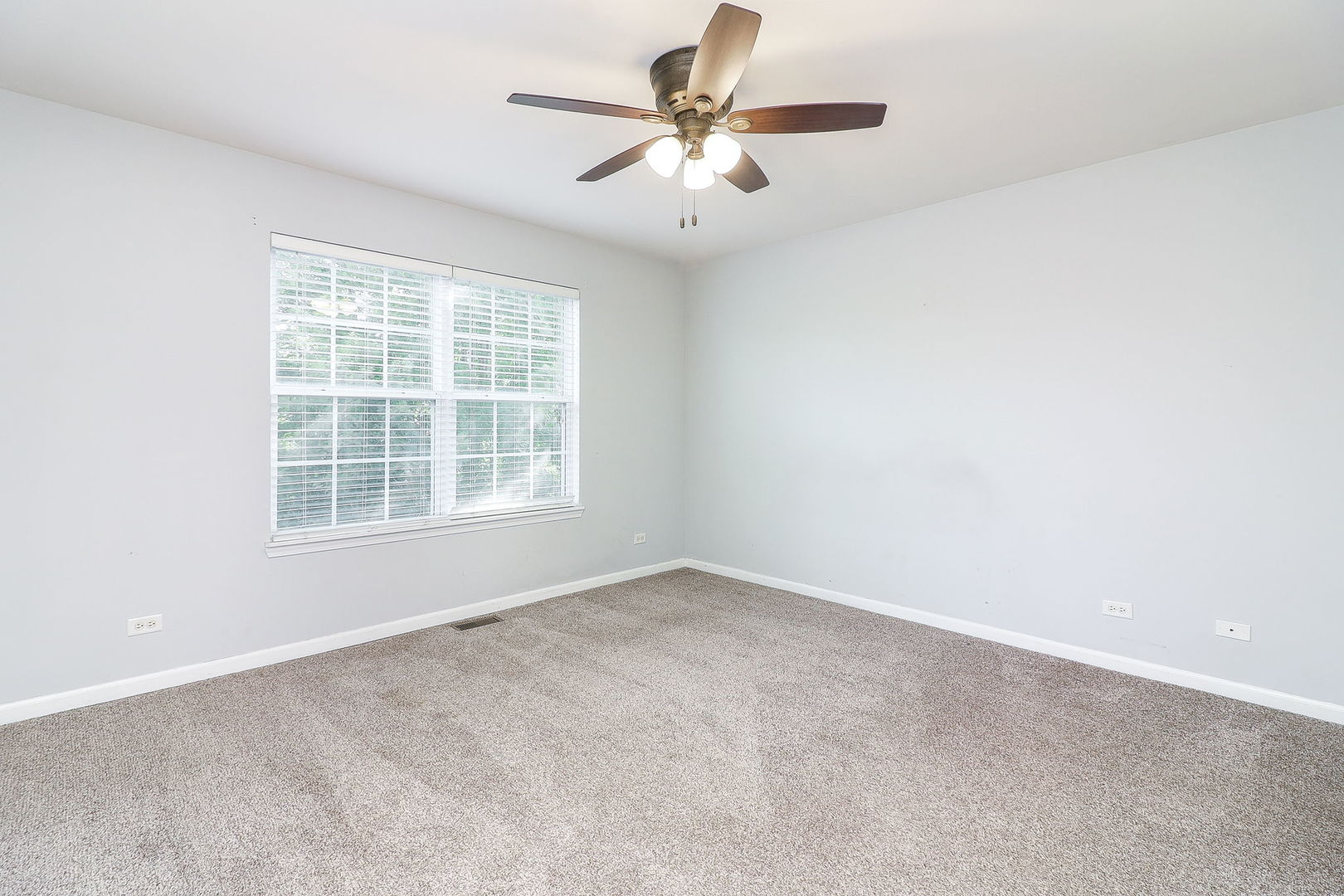 317 Timber Ridge Court, Unit 131 Joliet, IL 60431 - Photo 13 of 23 an empty room with windows and chandelier fan