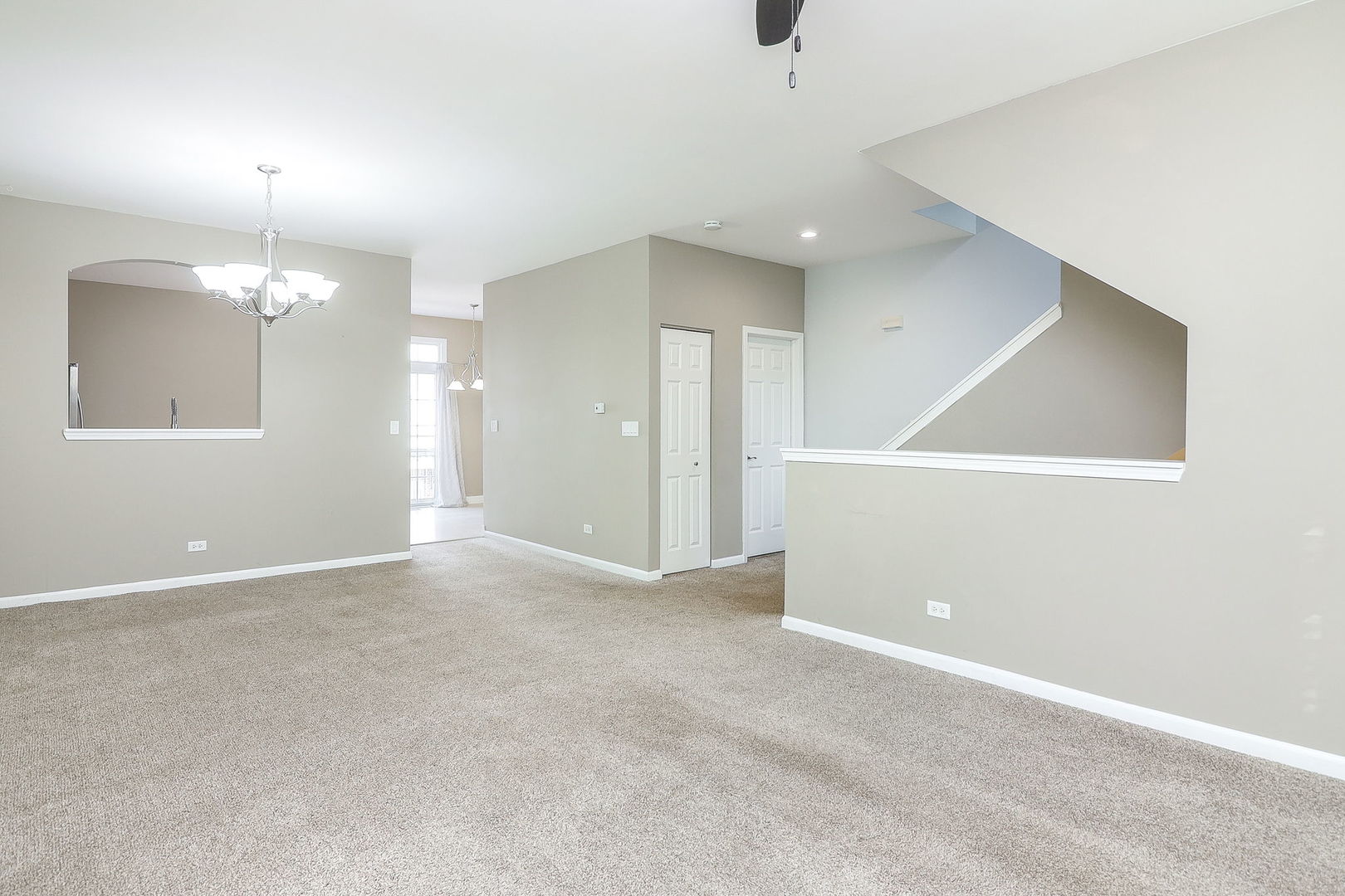 317 Timber Ridge Court, Unit 131 Joliet, IL 60431 - Photo 4 of 23 an empty room with chandelier fan and windows