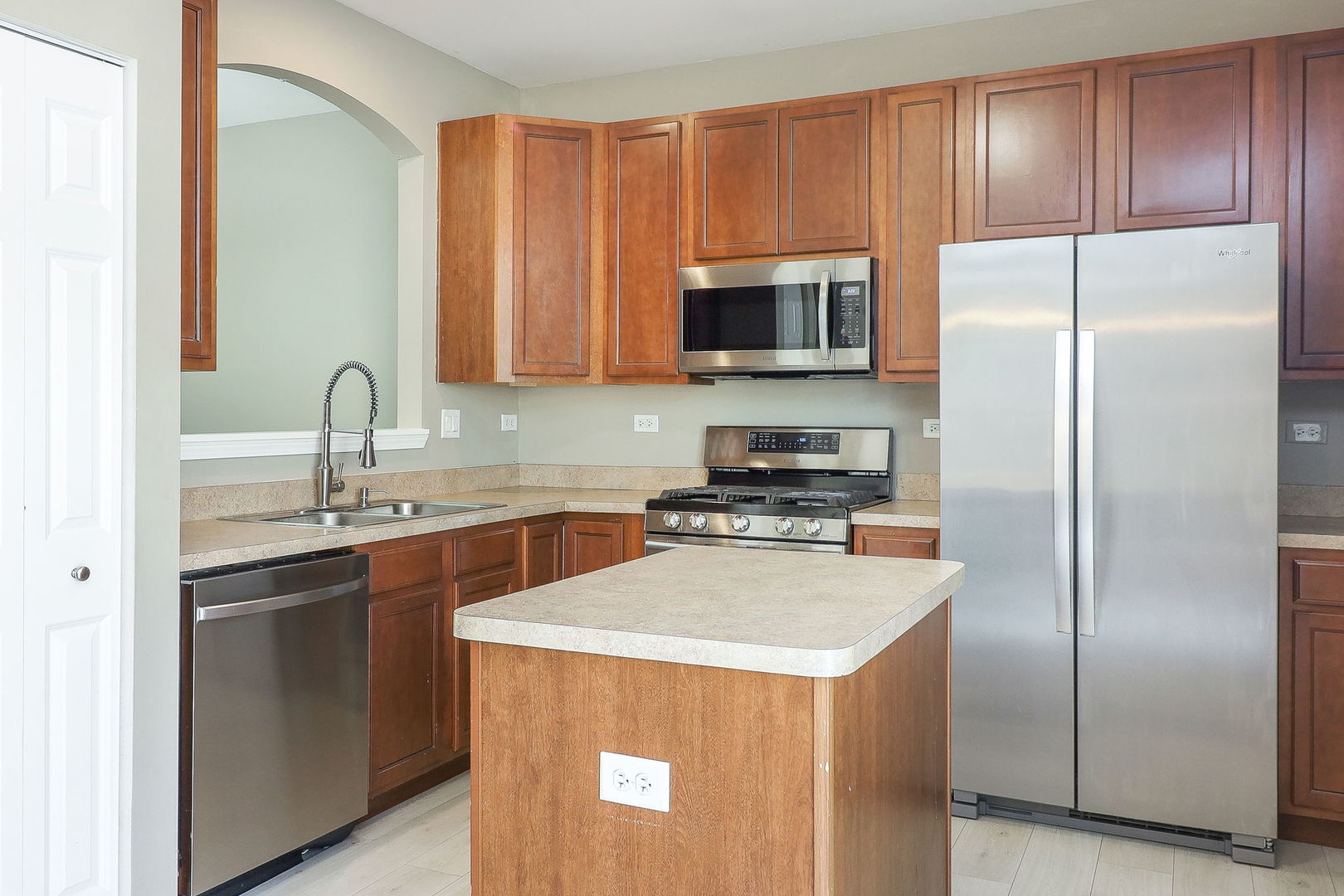 317 Timber Ridge Court, Unit 131 Joliet, IL 60431 - Photo 8 of 23 a kitchen with stainless steel appliances granite countertop a refrigerator a sink a stove a microwave and island
