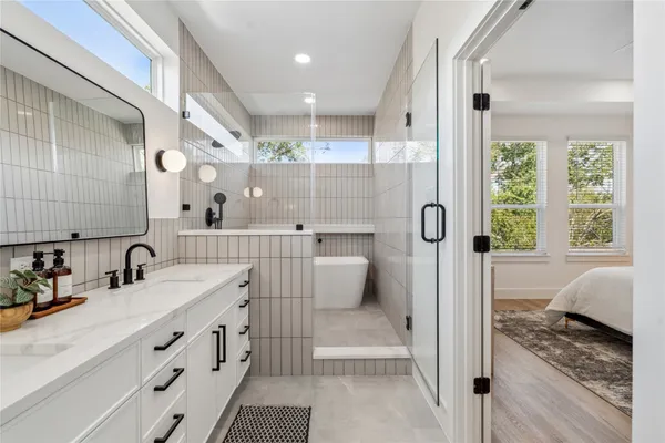 a bathroom with a double vanity sink mirror and shower