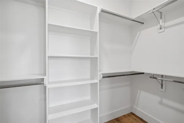 a view of walk in closet with empty racks