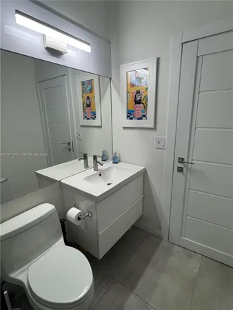 a bathroom with a sink mirror vanity and toilet