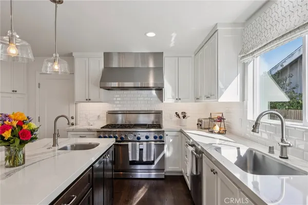a kitchen that has a lot of cabinets in it and wooden floors