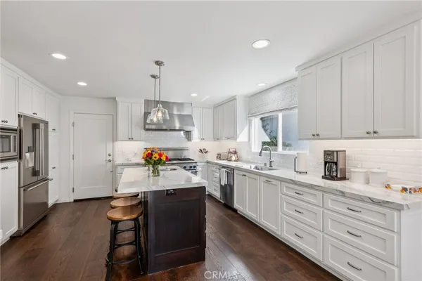 a kitchen with stainless steel appliances a sink stove and cabinets