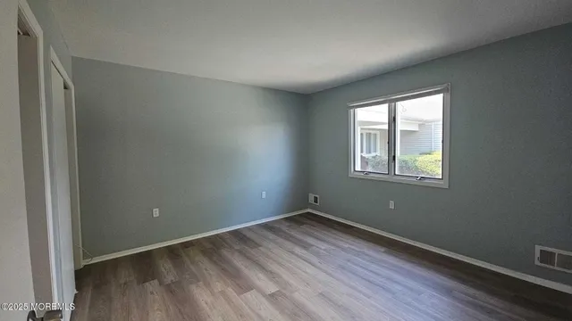 a view of a room with wooden floor and windows in it