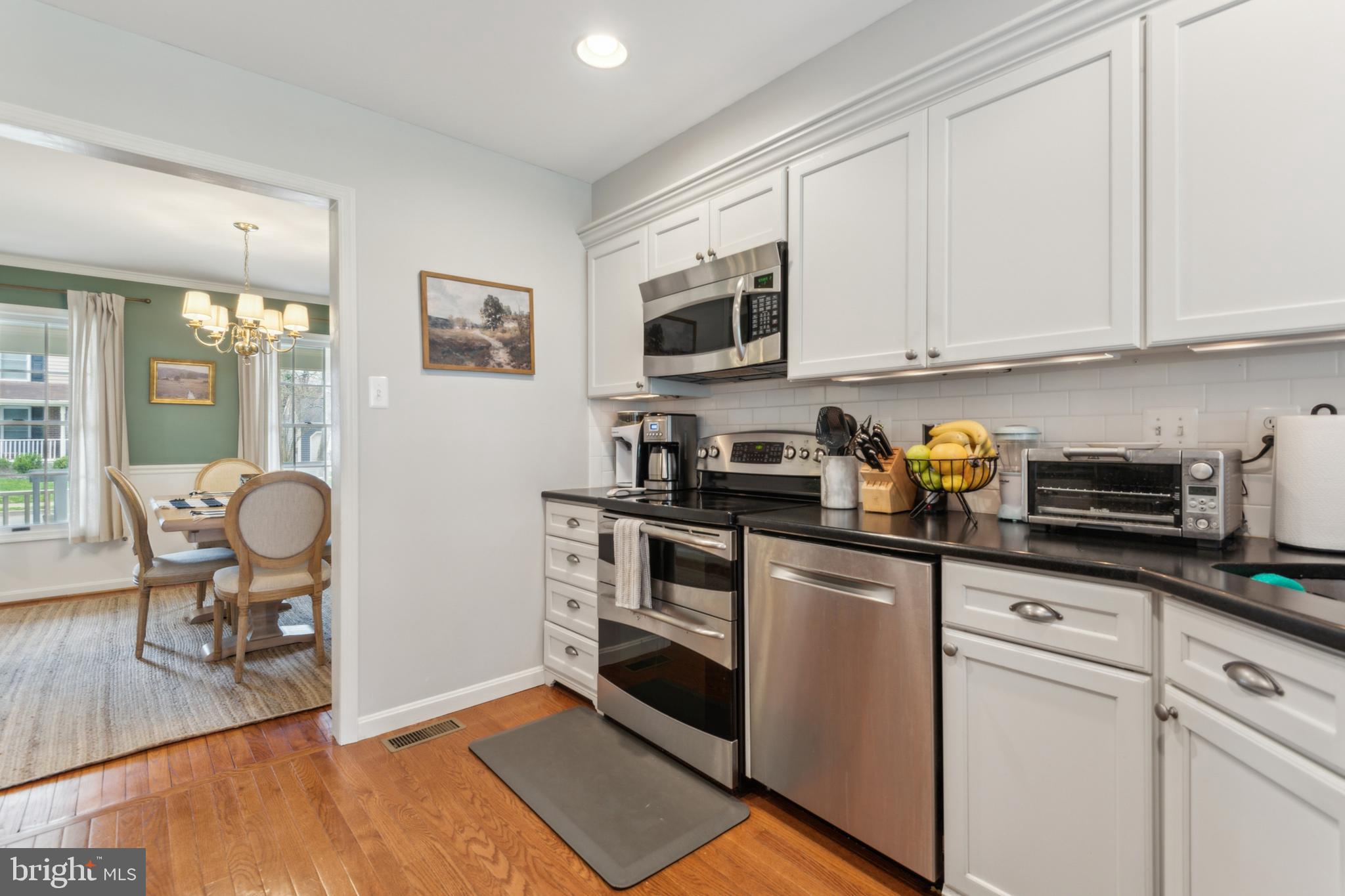 306 Saddle Ridge Road Annapolis, MD 21403 - Photo 17 of 44 a kitchen with stainless steel appliances granite countertop a stove a sink dishwasher and white cabinets with wooden floor