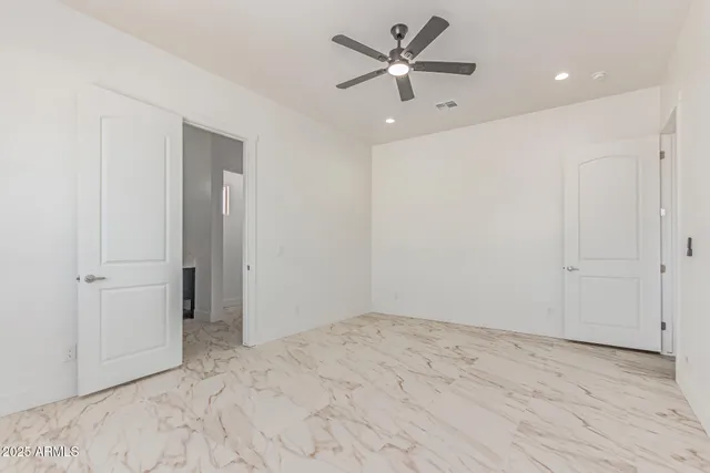 an empty room with fan and a ceiling fan