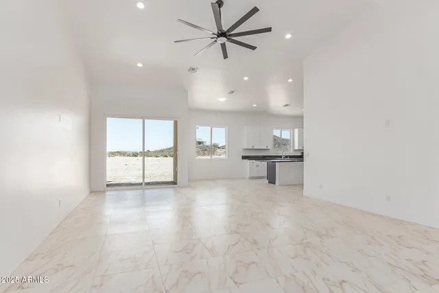 an empty room with fan and windows