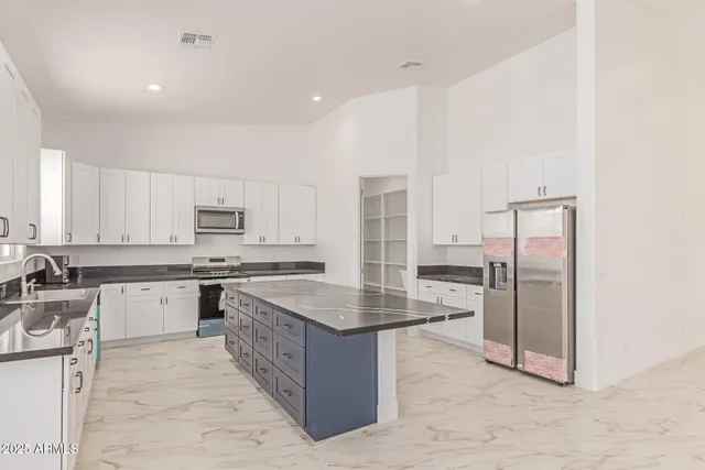 a open kitchen with stainless steel appliances granite countertop a stove top oven a sink dishwasher and a refrigerator