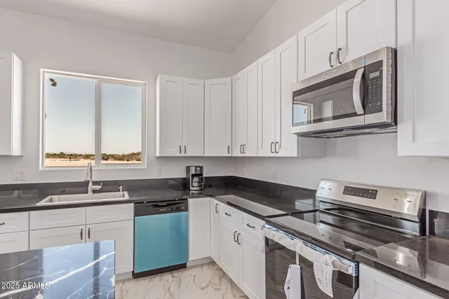 a kitchen with cabinets stainless steel appliances and a sink