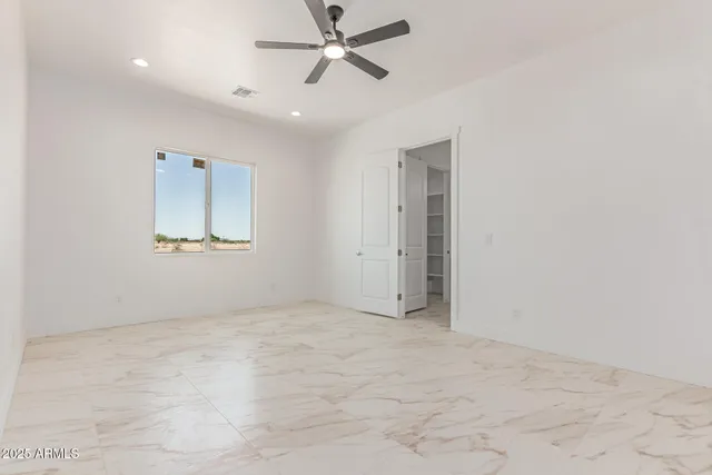 an empty room with fan and windows