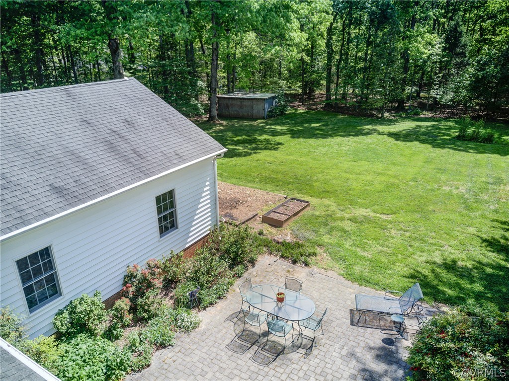 1607 Genito Road Crozier, VA 23039 - Photo 29 of 49 a backyard of a house with table and chairs plants and large tree