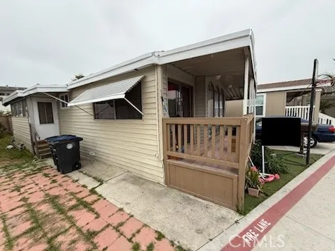 a view of house with black door and wooden bench