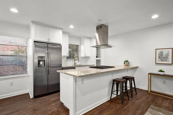 a kitchen with stainless steel appliances granite countertop a sink a stove a refrigerator and island