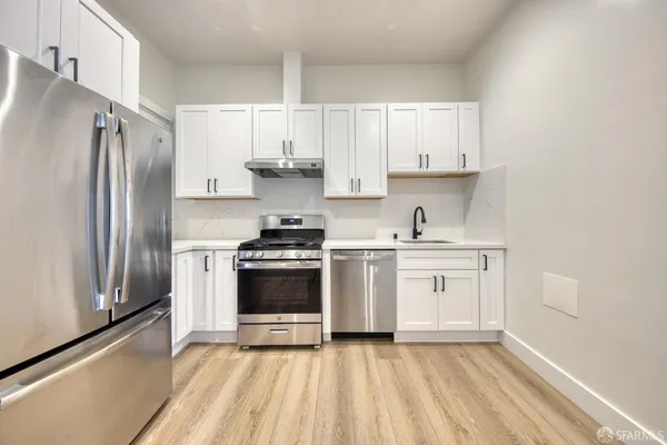 a kitchen with stainless steel appliances a refrigerator sink and cabinets