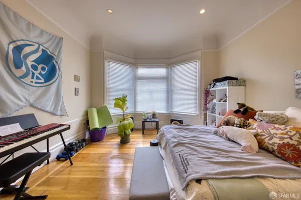 a bedroom with a bed a dresser and a chandelier