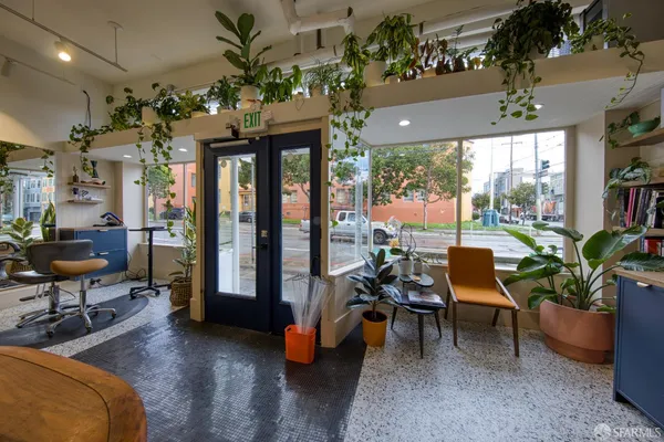 a living room with patio furniture and a potted plant