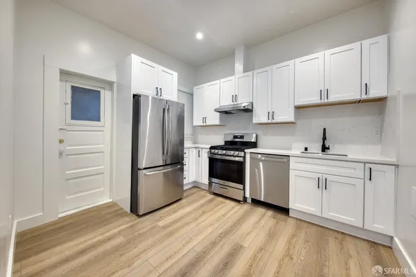 a kitchen with stainless steel appliances a refrigerator sink and cabinets