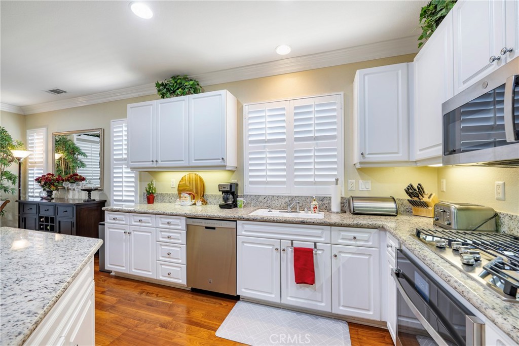 27956 Crystal Spring Drive Menifee, CA 92584 - Photo 26 of 75 a kitchen with a sink stove top oven and cabinets