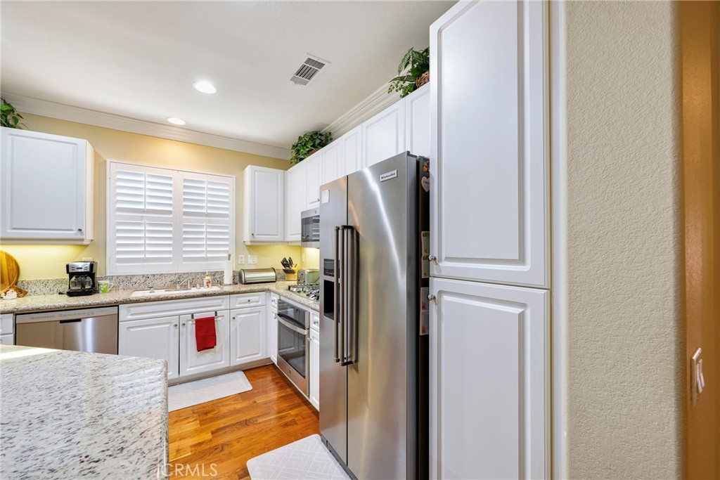 27956 Crystal Spring Drive Menifee, CA 92584 - Photo 27 of 75 a kitchen with stainless steel appliances granite countertop a refrigerator and a stove