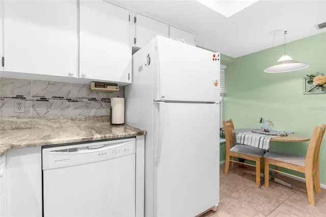 a kitchen with a sink a refrigerator and cabinets
