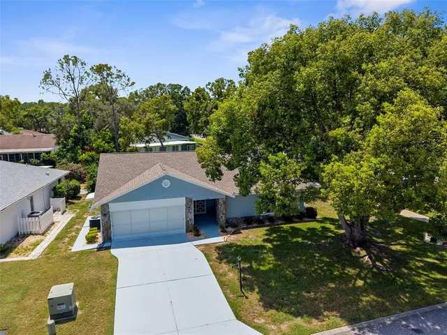 an aerial view of residential houses with outdoor space and trees