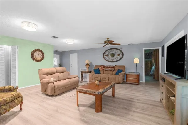 a living room with furniture and a wooden floor