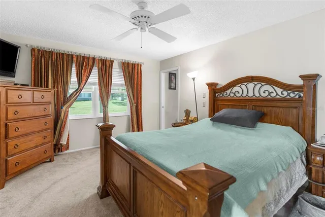 a bedroom with a bed and a ceiling fan