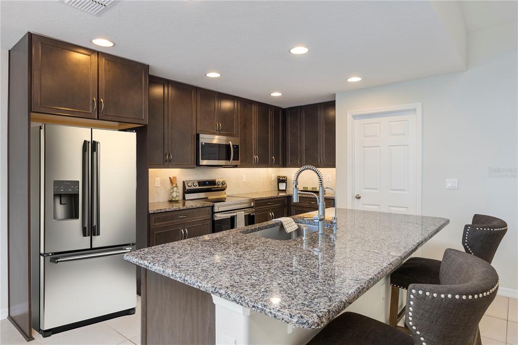 10 Rale Place Palm Coast, FL 32164 - Photo 4 of 27 a kitchen with stainless steel appliances granite countertop a sink refrigerator and microwave