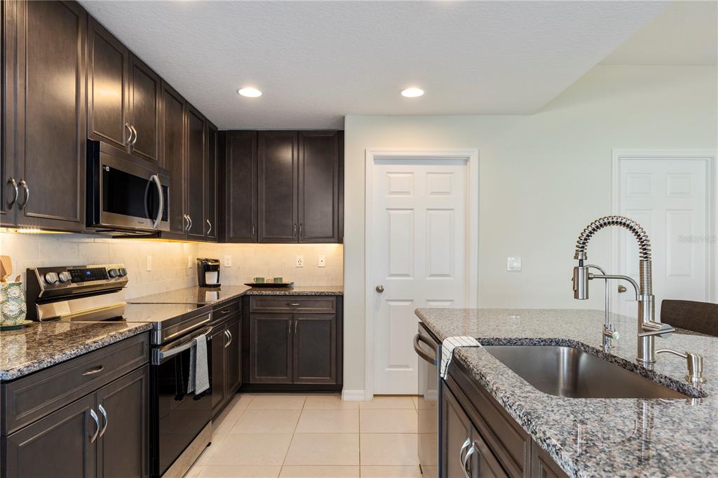 10 Rale Place Palm Coast, FL 32164 - Photo 5 of 27 a kitchen with stainless steel appliances granite countertop a sink stove and refrigerator