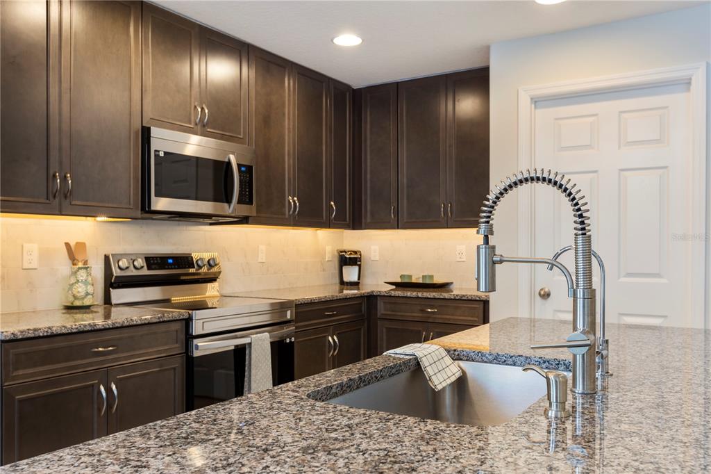 10 Rale Place Palm Coast, FL 32164 - Photo 7 of 27 a kitchen with granite countertop stainless steel appliances and wooden cabinets