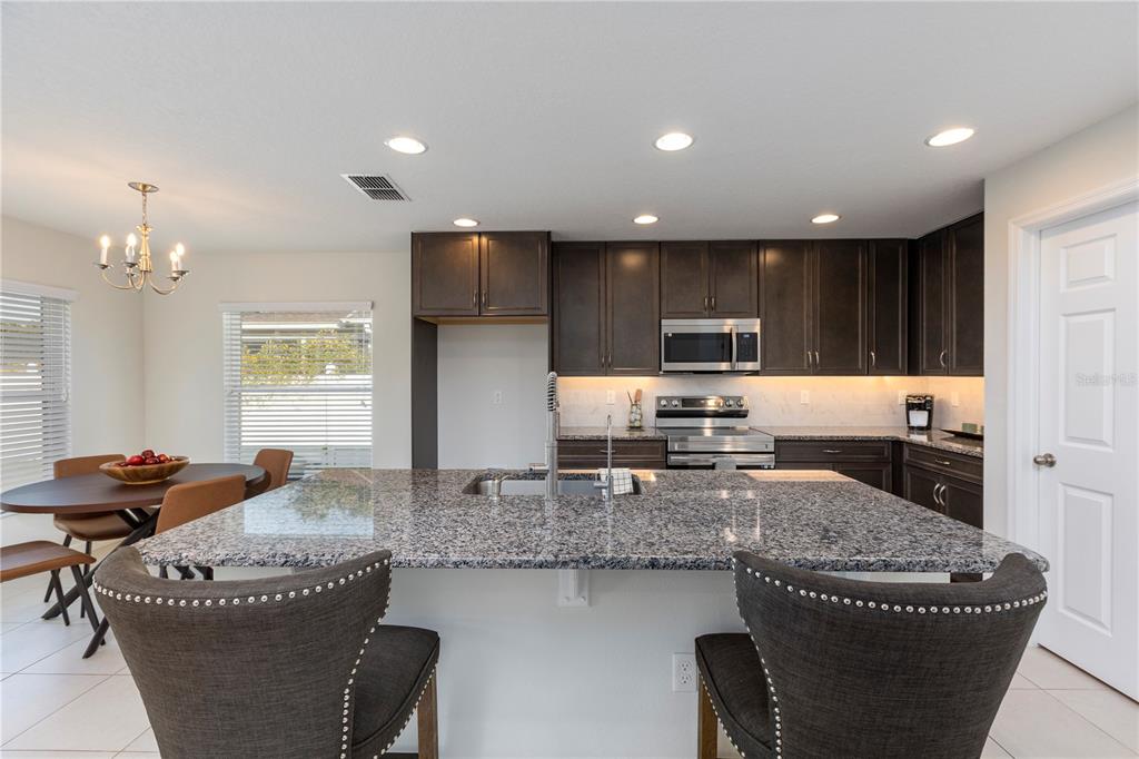 10 Rale Place Palm Coast, FL 32164 - Photo 9 of 27 a kitchen with granite countertop kitchen island stainless steel appliances a sink stove and cabinets